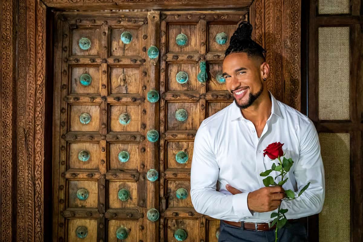 Wer ist der Bachelor 2023? - hier im Bild David Jackson im weißen Hemd mit einer Rose in der Hand