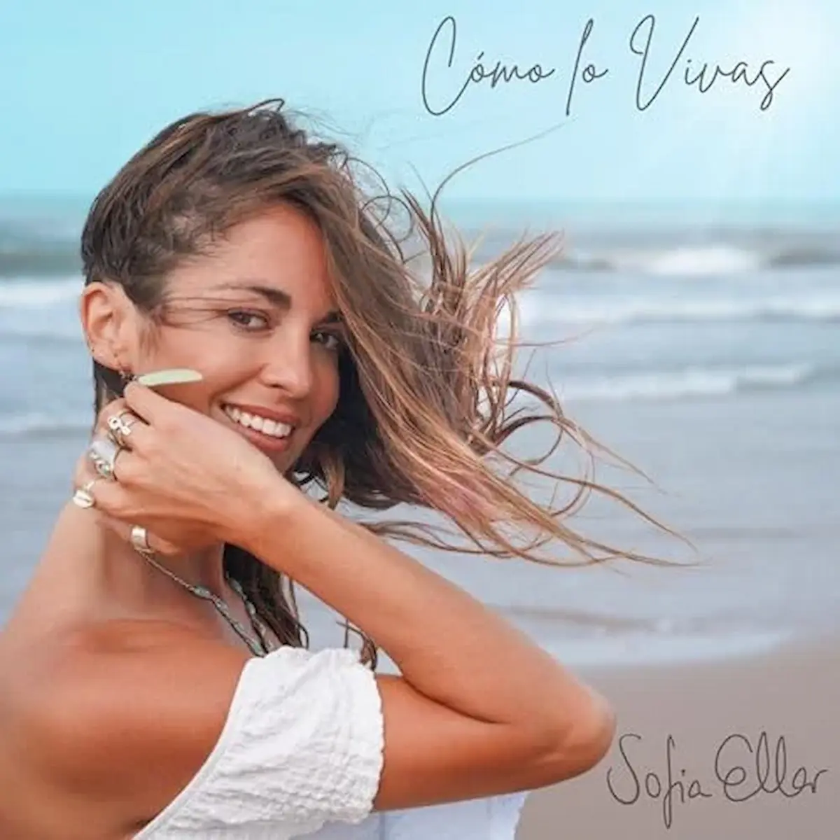 Sofia Ellar auf dem Cover zu ihrer Single "Como Lo Vivas" am Strand, sie lächelt in die Kamera