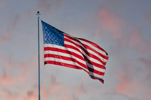 Eiskunstlauf, Isabeau Levito Erster Erfolg der Saison beim Cranberry Cup 2025 in den USA - auf dem Foto zur Illustration ist eine amerikanische Flagge zu sehen, die bei Sonnenaufgang im Wind weht