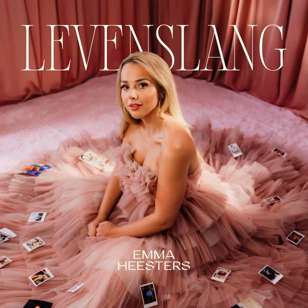 Emma Heesters erfolgreich mit Song „Levenslang“ - im Bild das Single-Cover mit einem Foto der Künstlerin, die in einem wallenden, rosafarbenen Kleid sitzt und in die Kamera schaut