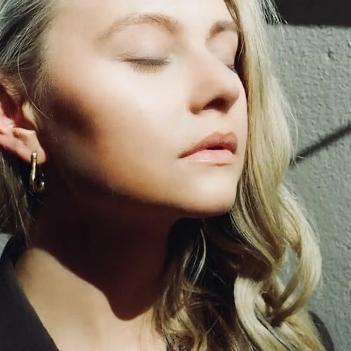 Lusaint 2025 - Summertime - hier im Bild das Single-Cover mit einer Großaufnahme des Gesichts von Lusaint, die das mit geschlossenen Augen in die Sonne hält