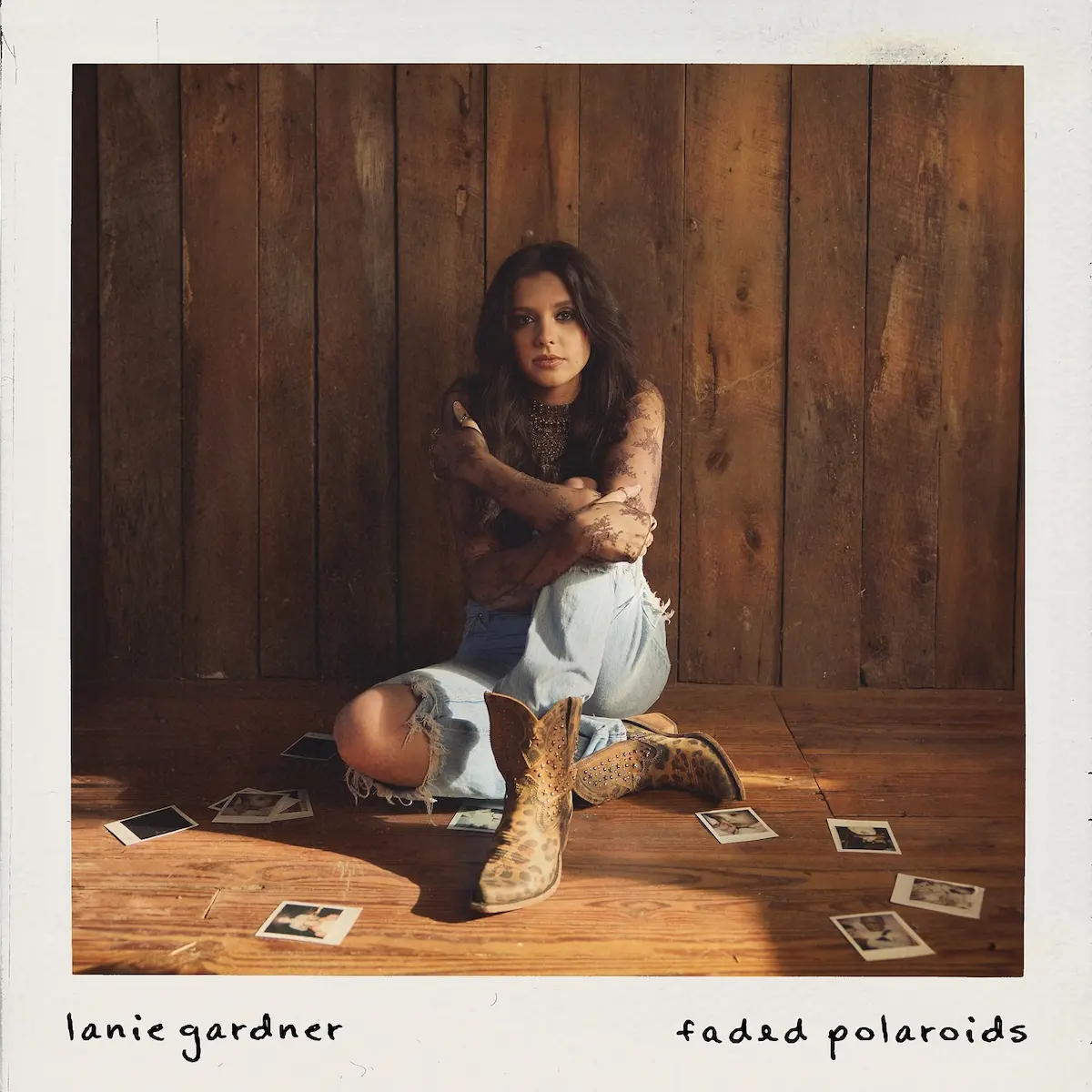 Country-Musik 2025 Lanie Gardner Album „Faded Polaroids“ veröffentlicht - hier im Bild das Album-Cover mit einem Foto der Künstlerin, die auf dem Boden sitzt mit einigen Polaroids um sie verstreut
