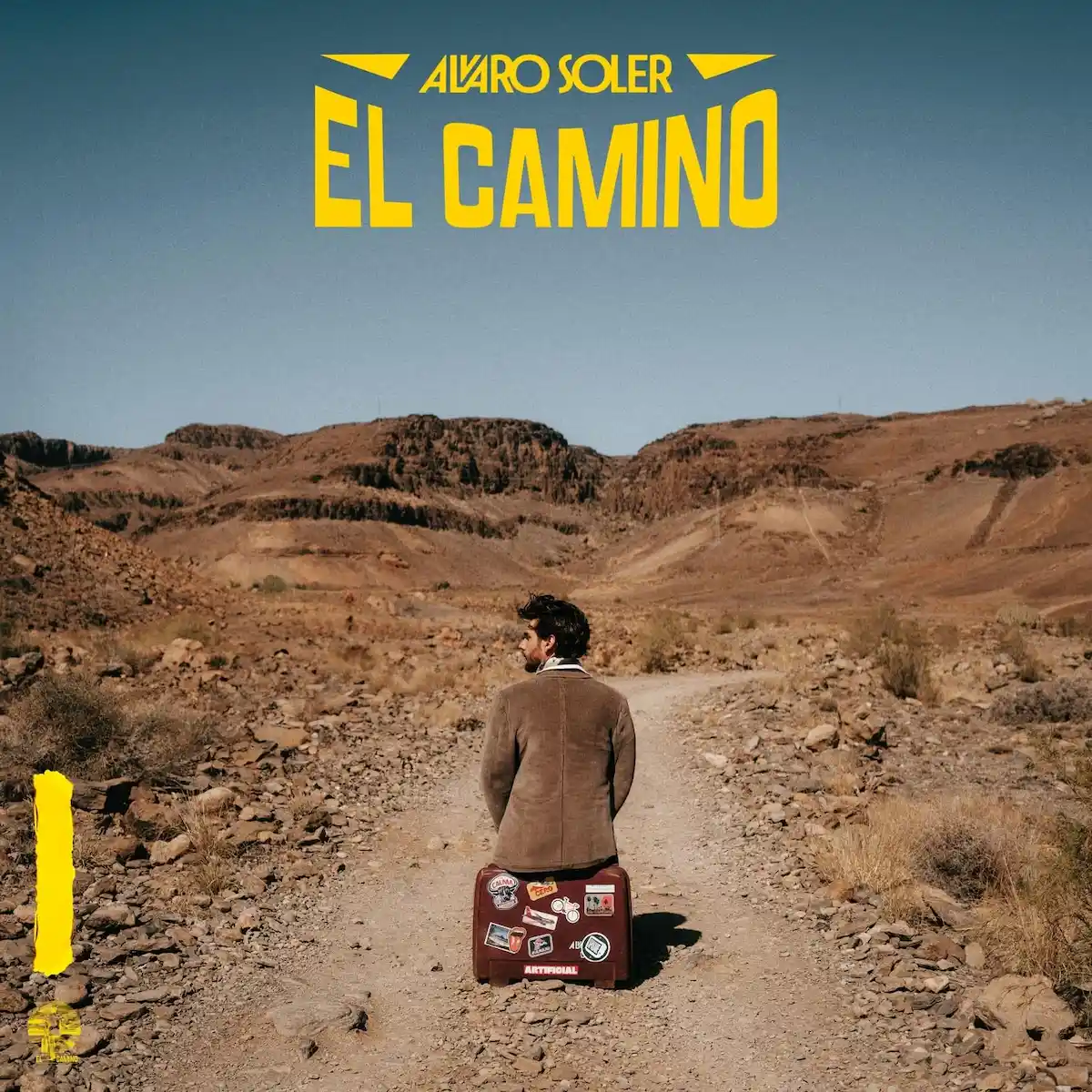 Alvaro Soler Album „El Camino“ und Konzerte 2026 - hier im Bild das Album-Cover mit Alvaro Soler, der auf einem Koffer sitzt auf einem Weg, der in die weite Landschaft führt