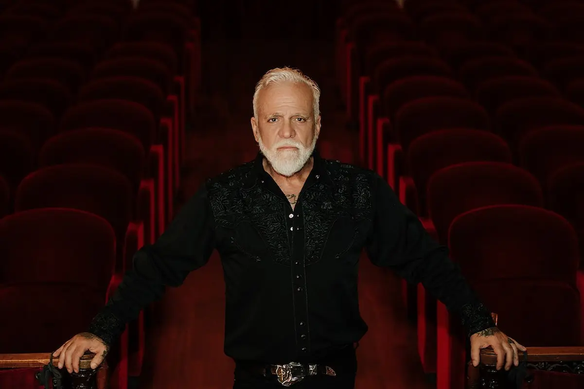 Nino de Angelo 2026 - Konzert-Termine, Städte, Orte, Ticket-Tipps - hier im Bild der Künstler, der in einem leeren Konzertsaal im Gang zwischen den Sitzreihen steht