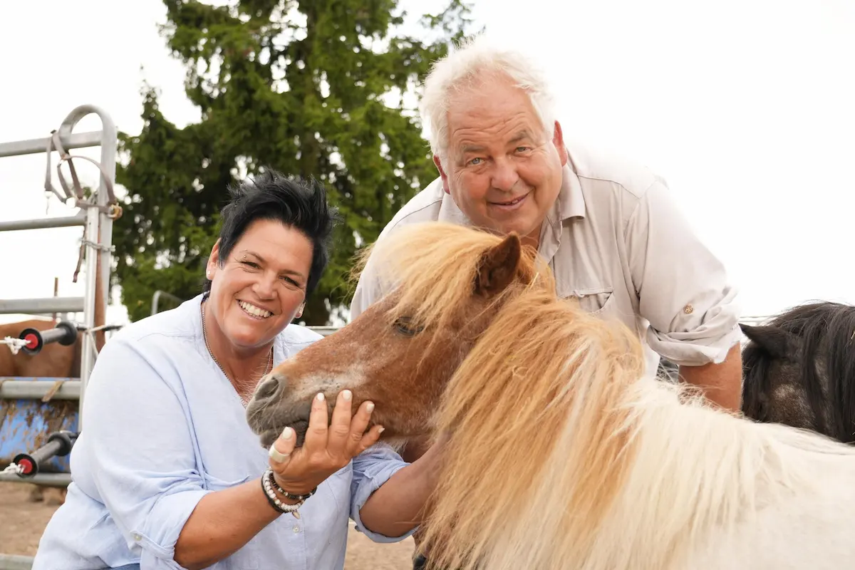 Simone und Frank stehen gemeinsam bei einem Pony und strahlen um die Wette. Das Foto fängt die harmonische Stimmung zwischen der Gnadenhof-Besitzerin und ihrem Gast ein. In Folge 10 zeigt sich Simone sichtlich beeindruckt von Franks ehrlicher Art, was sie dazu bewegt, ihm sogar ihr Haus und ihr Herz zu öffnen.