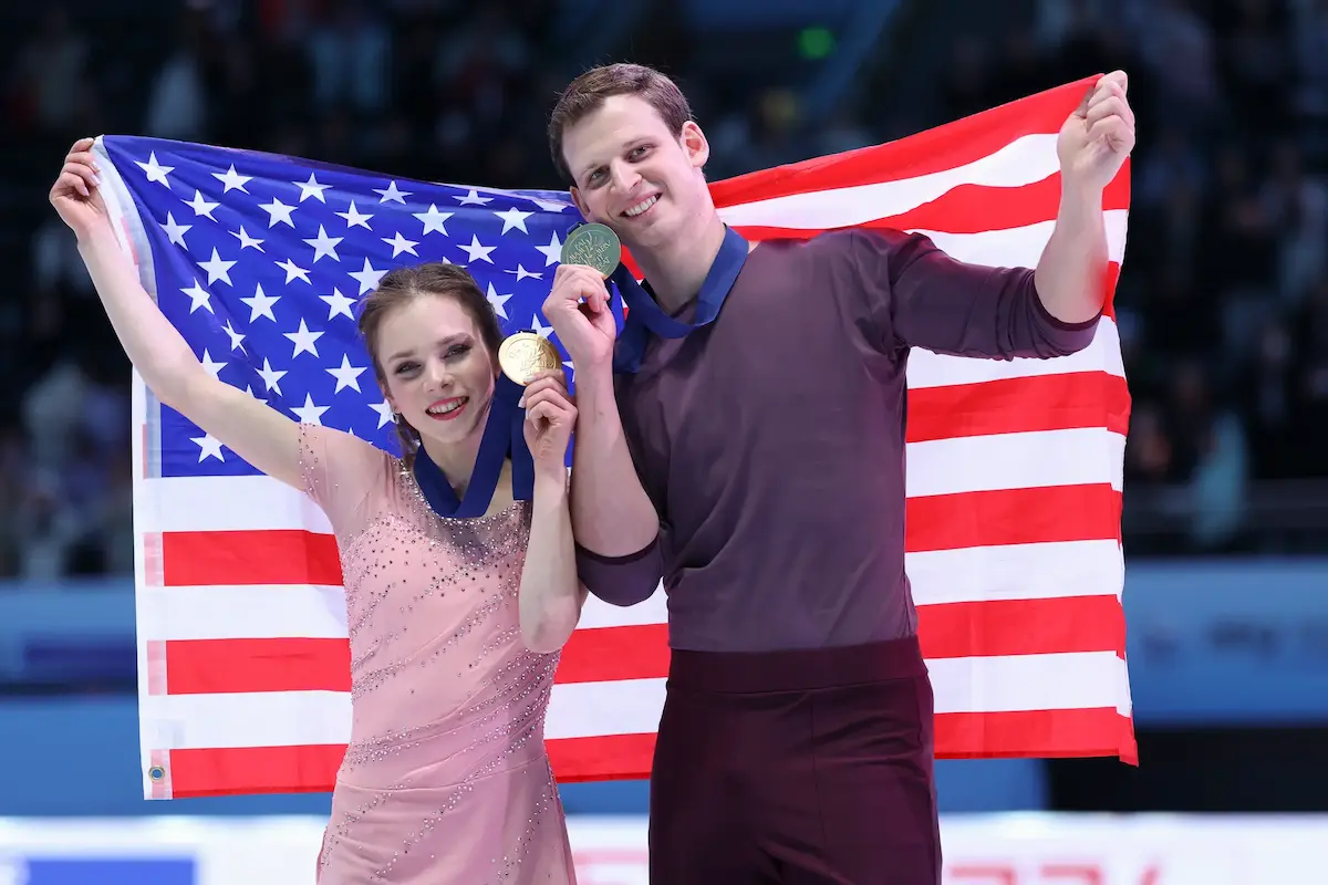 Alisa Efimova - Misha Mitrofanov aus den USA - 4CC-Meister 2026 bei den Eiskuntlauf-Paaren - das Eiskuntlauf-Paar nach der Siegerehrung - beide Sportler halten ihre Goldmedaillen in der Hand und hinter sich eine US-Flagge, beide lächeln in die Kamera