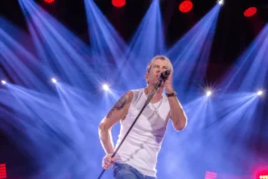 Matthias Reim Konzerte 2026 „Verdammt, ich lieb Dich“ - Tournee - Termine, Städte, Ticket-Tipps - das Bild zeigt den Sänger auf einer Konzertbühne - im Hintergrund strahlen Scheinwerfer in mehreren Reihen mit Lichtkegeln, die auf den Künstler gerichtet sind