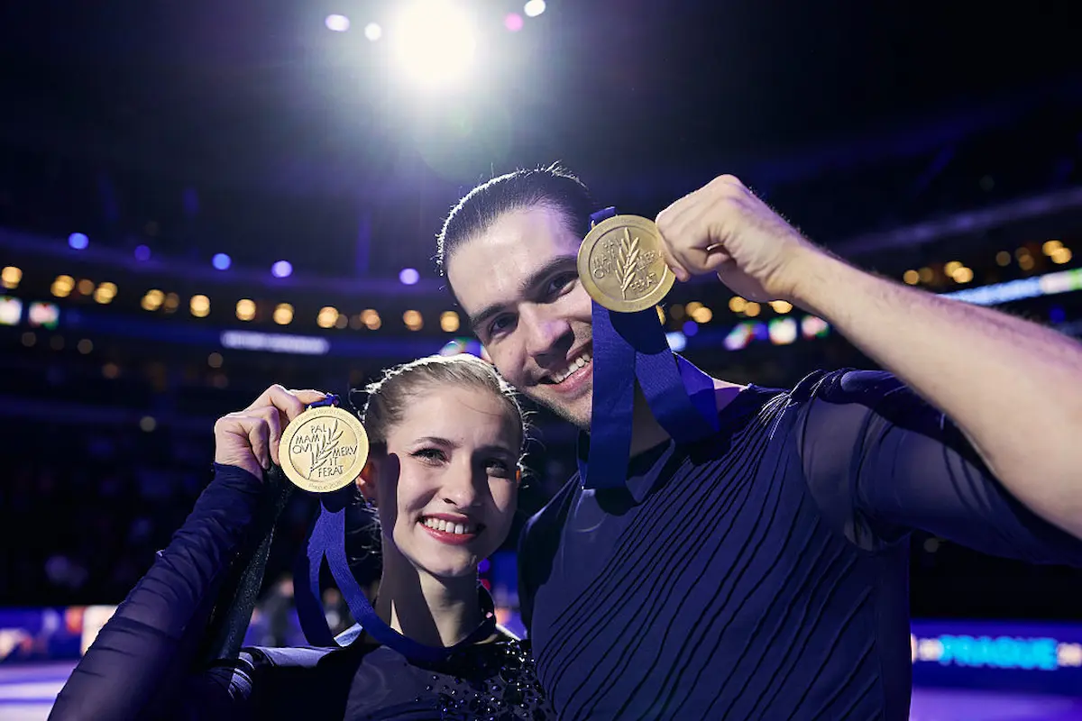 Minerva Fabienne Hase - Nikita Volodin aus Deutschalnd sind Weltmeister 2026 Eiskunstlauf-Paare - die beiden Eiskunstläufer halten lachend ihre Goldmedaillen in die Kamera