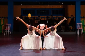 Ballett, Bolero, Tango - Viva la Vida - A Tribute to Frida Kahlo 2026-2027 Städte, Termine, Ticket-Tipps - das Bild zeigt eine Szene der Bühnenaufführung mit drei Tänzerinnen im Fokus und den Musikern im Hintergrund