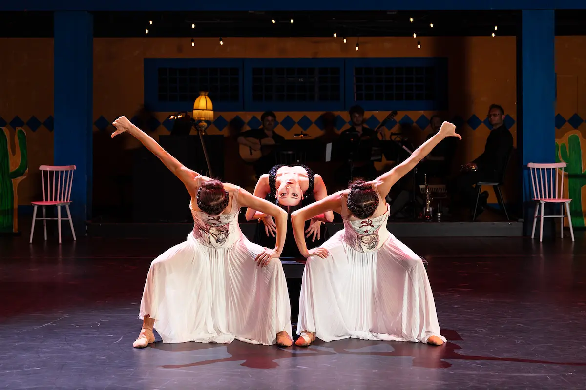 Ballett, Bolero, Tango - Viva la Vida - A Tribute to Frida Kahlo 2026-2027 Städte, Termine, Ticket-Tipps - das Bild zeigt eine Szene der Bühnenaufführung mit drei Tänzerinnen im Fokus und den Musikern im Hintergrund
