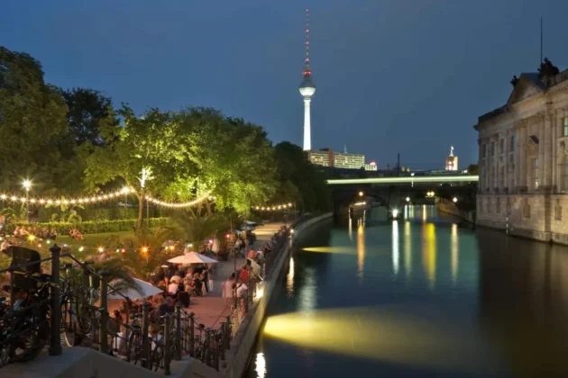 Tanzen Open Air im Monbijoupark am Bodemuseum in Berlin-Mitte - hier im Bild die Tanzfläche am Abend in stimmungsvolles Licht getaucht mit Blick von der Spreebrücke in Richtung Fernsehturm - links der Monbijoupark, rechts das Bodemuseum